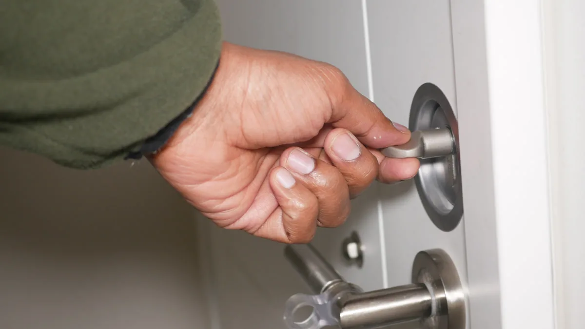 Person checking the lock on their front door at night with a porch light on