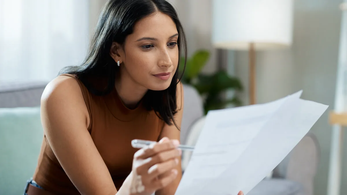 Woman sitting on a couch reviewing important documents