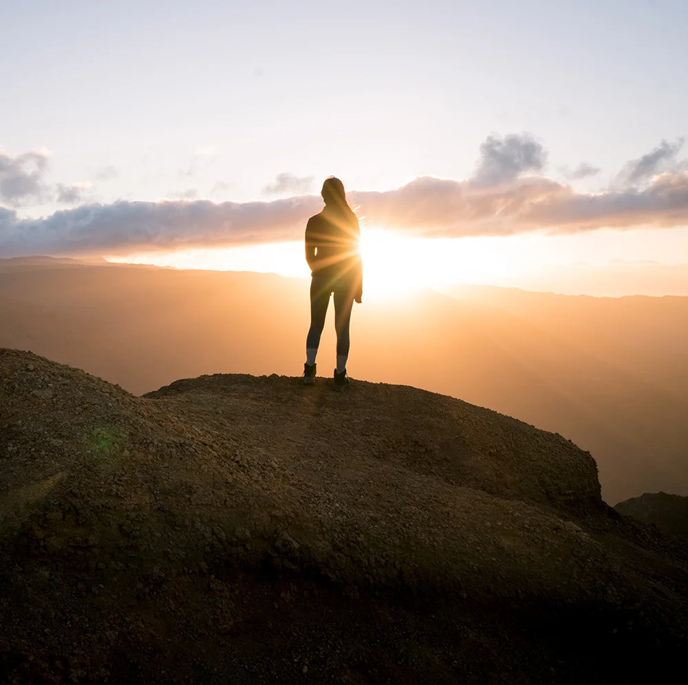 Solo hiker on a mountain trail at golden hour